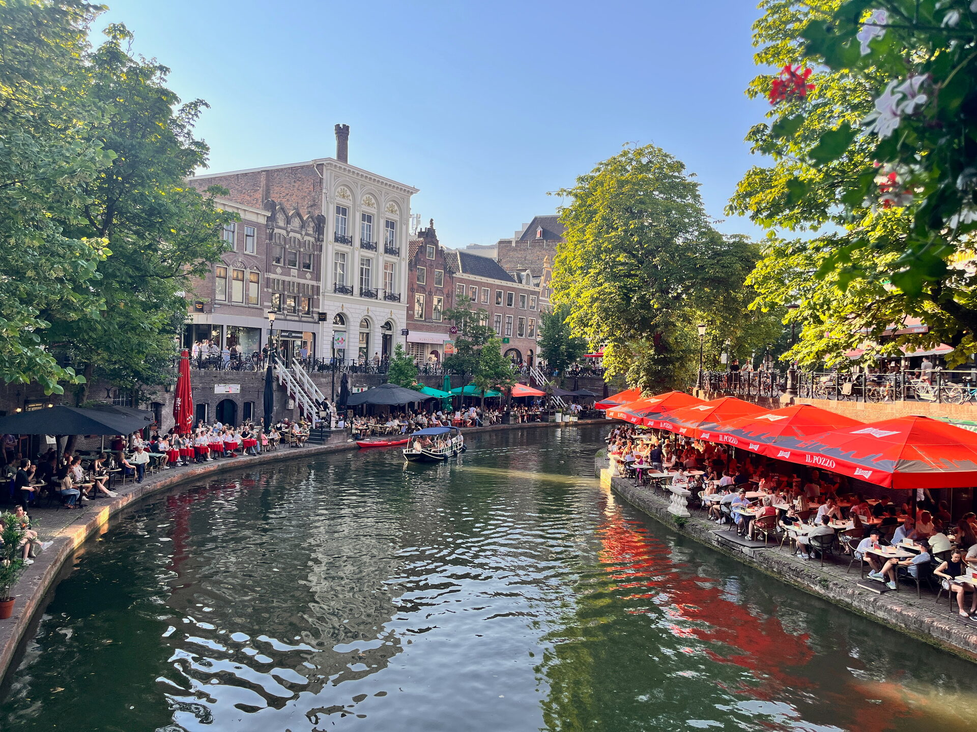 Terrassen met rode parasols op de werf langs de Oudegracht