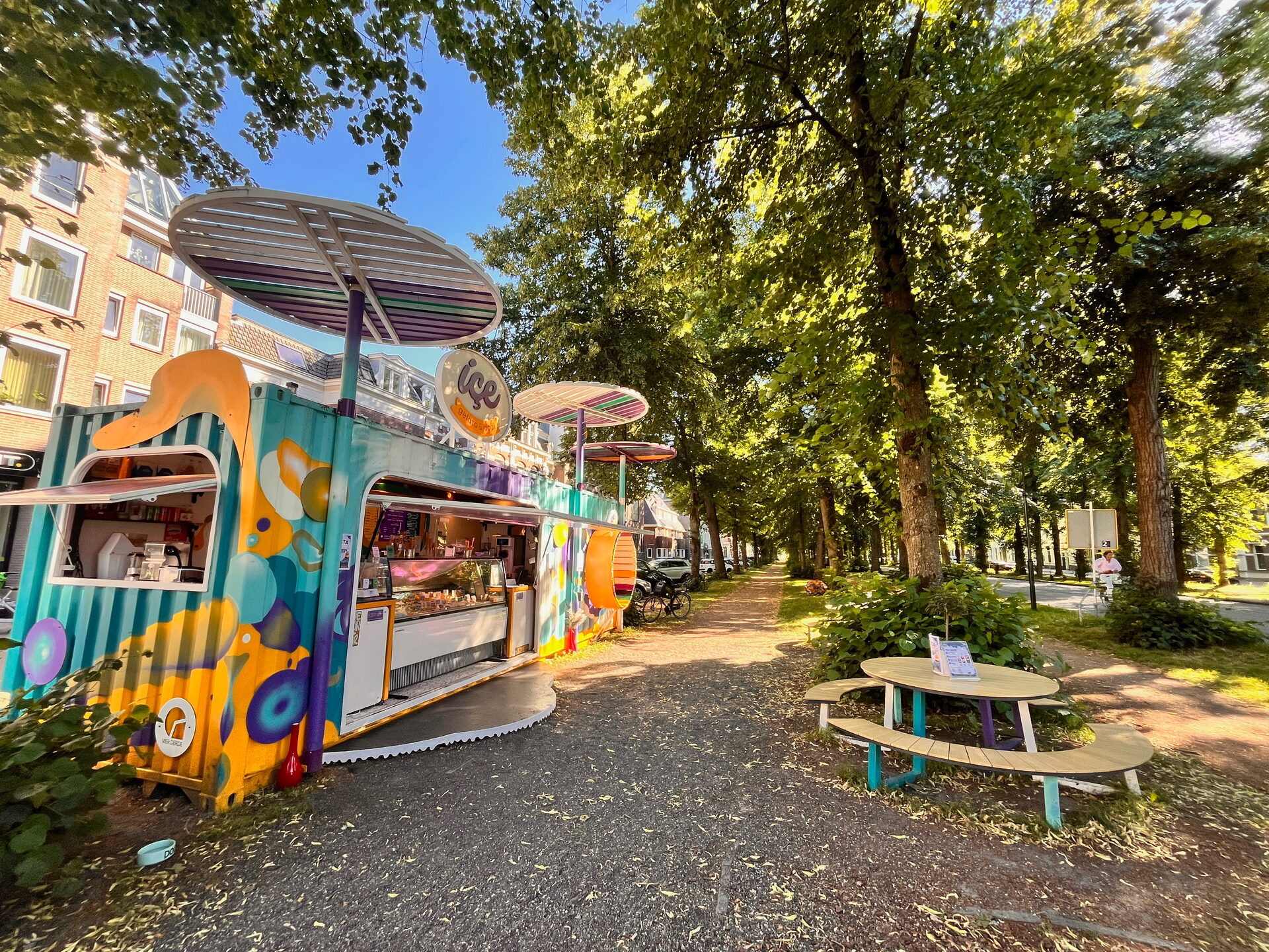 Kleurrijke kiosk onder de bomen met picknicktafels